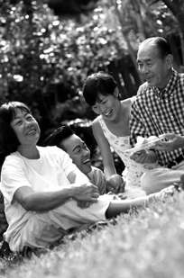 Photo of family enjoying a picnic on the grass.