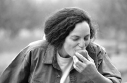 Photo of woman eating a fresh plum.