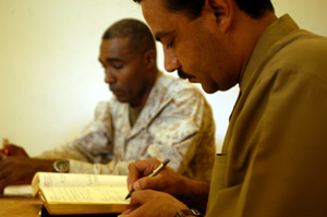 Thaer Handallah, an Iraqi government representative, schedules a future appointment with Maj. Rollin F. Jackson, a company commander with 3rd Battalion, 24th Marine Regiment, July 1, 2004, at Camp Habbaniyah, Iraq, after they signed a contract that gave Handallah $5,570 to buy new desks and other furniture for the school in Al Kabani, a nearby fishing village. The agreement is part of an ongoing effort by Marines intended to improve the quality of life of the communitys people. The reserve battalion, which provides security for nearby Camp Taqaddum, the home to the 1st Force Service Support Groups headquarters, has spent more than $175,000 helping the village through various projects. Jackson is a 37-year-old native of OFallon, Mo. Photo by: Lance Cpl. Samuel Bard Valliere