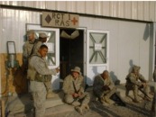 Marines are gathered in front of the Regimental Aid Station (RAS); click here to enlarge the photo.