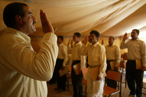Fifteen graduates from Camp Al Asad's Iraqi Border Police Academy swear an oath after graduating their training course.  The course was a first for western Al Anbar Province.  
(USMC photo by Sgt. Jose L. Garcia) Photo by: Sgt. Jose L. Garcia
