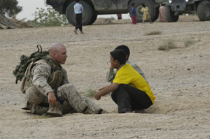 1st Lt. Joshua P. Batter, from Saint Paul, Minn., speaks with Iraqi children in their village outside of Fallujah, Iraq.  Marines repositioned forces outside their city allow Iraqis to take over security for themselves.
(USMC Photo by Pfc. B.E. Loveless) Photo by: Pfc. B.E. Loveless