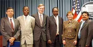 Photo of USTR Robert Zoellick and USDA Secretary Ann Veneman with four participants following the May 13, 2003, press conference announcing the WTO case against the EU on biotech products (five men, one woman facing camera).