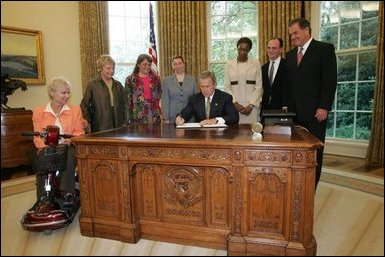 President George W. Bush signs an executive order for individuals with disabilities in emergency preparedness Thursday, July 22, 2004 in the Oval Office.