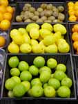 Photograph of lemons and limes on display at a grocery store.