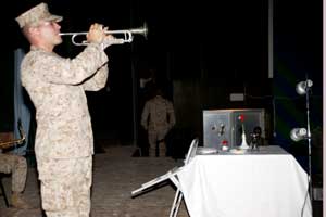 During the 229th celebration of the Navy Birthday, 27-year-old Bristol, Wis., native Sgt. Michael A. Flaningam, trumpet player, 3rd Marine Aircraft Wing Band, plays 'Taps' in front of the Prisoner of War/Missing in Action table setting during a commemorative portion of the ceremony. The birthday ceremony was held at the base theater aboard the air base at Al Asad, Iraq, Oct. 15. Photo by:Cpl. Joel A. Chaverri