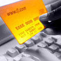 person holding a credit card at a computer keyboard