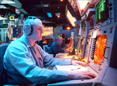 Photo of operator at computer terminal, caption immediately follows