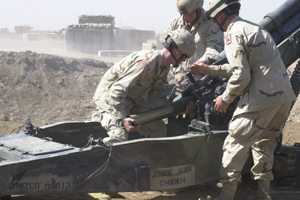 An Arkansas Army National Guard howitzer crew, from the 1st Battalion, 206th Field Artillery, conducts a fire mission at Camp Cooke in Iraq in late September. They are members of the Army Guards 39th Brigade Combat Team.