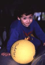 Photo of child with mental retardation playing with a ball.