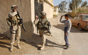 Army Sgt. 1st Class John R. Coomer, from Logan, Ohio and a platoon sergeant for Company C, 3rd Battalion, 505th Parachute Infantry Regiment, speaks with a local Iraqi boy about any suspicious people in his neighborhood. Observing closely is 1st Lt. John E. Pettinelli from Weymouth, Mass., a platoon commander in Company G, 2nd Battalion, 2nd Marine Regiment, 1st Marine Division. Marines are accompanying soldiers on patrols of their operational areas so they can get a feel for the environment and build upon the soldiers' months of experience in dealing with the local population before they take over operational responsibility of the area. (Official U.S. Marine Corps photo by Cpl. Shawn C. Rhodes) Photo by: Cpl. Shawn C. Rhodes