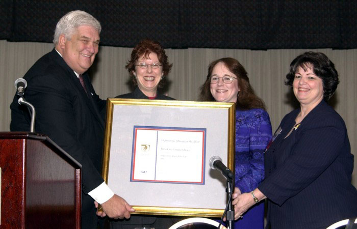 Bruce James & Judy Russell present Depository of Year
                  Award to Linda Saferite & Suzanne Sears