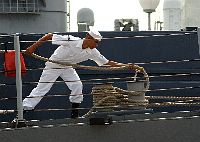 A line-handler aboard the guided missile frigate USS Reuben James (FFG 57) adds slack to a mooring line while preparing the ship for getting underway. 