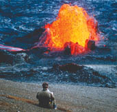 Imagen de un hombre sentado cerca de una erupcin de lava en el volcn Kilauea, Hawaii