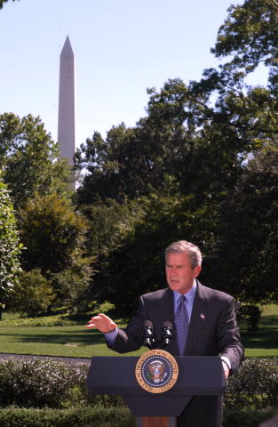 President Bush speaks at a podium with the Washington Monument in the background.