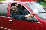 Photograph of a red car and man with gun