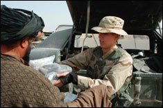 Spc. Janei Worley with the 308th Tactical Psychological Operations Company presents radios to the village leader in Haji Lalay Kalacha, Afghanistan Sept. 30. 