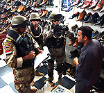 Iraqi National Guard interviews shopkeeper.