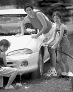 photo of mother and two children washing a car