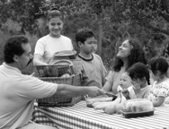 photo of family with food at picnic table