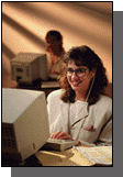 Picture of woman sitting at a computer screen accessing the Office of the Inspector General web site.