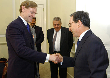 A.Uribe saluda a R.Zoellick; R.Hommes mira