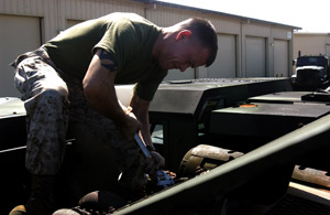 Lance Cpl. Luke Alsup uses a wrench to loosen the bolts that hold the exhaust system of his dragon wagon in place in order to replace the old system. Photo by: Sgt. Jereme L. Edwards
