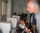 USAID Administrator Natsios with students at computers.