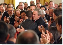 President George W. Bush embraces Brazilian Musician Alexandre Pires after his performance during the Celebration of Hispanic Heritage Month in the East Room, Thursday, Oct 2, 2003. White House photo by Tina Hager.