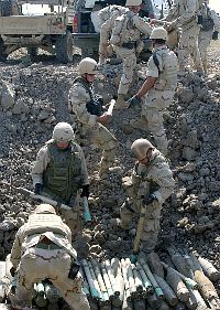 Navy Explosive Ordnance Disposal (EOD) technicians assigned to the Bahrain-based Special Operations Task Force 56, work with Army EOD technicians to prepare unexploded ordnance (UXO) for demolition