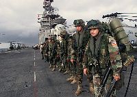 Marines from the 26th Marine Expeditionary Unit (MEU) wait on the flight deck of USS Iwo Jima prior to boarding one of nine helicopters bound for Monrovia, Liberia