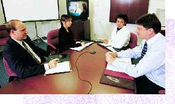 Image of four people around a conference table