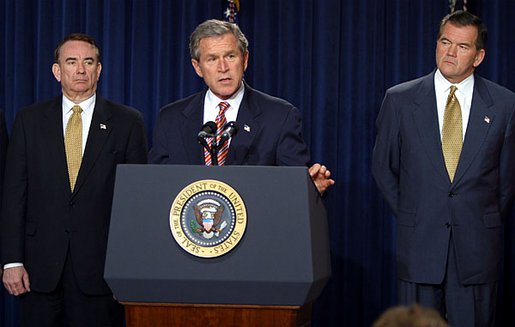 President George W. Bush discusses his smallpox vaccination program during a press conference as Secretary of Health & Human Services Tommy Thompson, left, and Director of the Office of Homeland Security Tom Ridge in the Dwight D. Eisenhower Executive Office Building Friday, Dec. 13. White House photo by Paul Morse