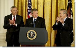 President George W. Bush delivers remarks at the signing of The Emergency Supplemental Appropriations Act for Defense and for The Reconstruction of Iraq and Afghanistan in the East Room Thursday, Nov. 6, 2003. Pictured with the President are Secretary of State Colin Powell, left, and Defense Secretary Donald Rumsfeld. White House photo by Susan Sterner