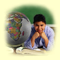 A boy with elbows on desk and resting chin on hands studying a globe.