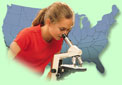young girl looking into a microscope with the United States behind her.