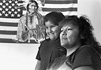 Image of Pima mother and daughter in front of an American Pima flag.