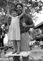 Picture of young girl and her father playing on the swing
