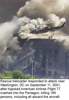 Rescue helicopter hovers over the Pentagon engulfed in smoke, while responding to attack near Washington, DC on 9/11 after hijacked American Airlines Flight 77  crashed into the Pentagon, killing 189 persons, including all aboard the aircraft.