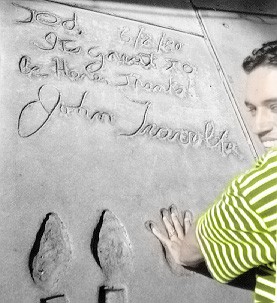 Filipe examine the foot and handprints of John Travolta at Mann's Chinese Theater in Hollywood.