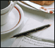 Photo of a news item on a dining table with coffee