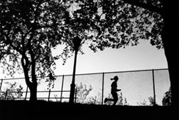 Photo of jogger running in park in silhouette