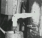 Photograph of lead being poured into billet mold.