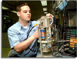 Aviation Electronics Technician performing maintenance, aligns the inductor network on a coupler.  US Navy Photo.