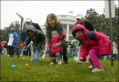 Slipping and sliding, eggs are tossed in rainy race on the South Lawn during the 2004 White House Easter Egg Roll Monday, April 12, 2004. Because of inclement weather, the annual event closed at noon.