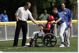 Former Major League pitcher Jim Abbott congratulates a player from the Challenger Phillies from Middletown, Delaware at Tee Ball on the South Lawn at the White House on Sunday July 11, 2004. White House photo by Paul Morse.