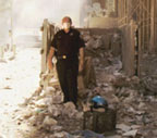 photo - officer stands amongst disaster