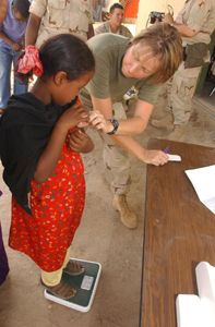 HM1 Cynthia Spragg, hospital corpsman, checks a Djiboutian girl's temperature and weight during a Medical Civil Action Program in As Eyla, July 19. The MEDCAP was held to support the Combined Joint Task Force - Horn of Africa mission of detecting, disrupting and defeating transnational terrorists in the region.   Photo by: Sgt. Bradly Shaver