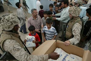 Cpl. Joseph E. Willis, a civil affairs Marine, reaches for another book bag for another student at a Kharma school May 22. The 3rd Civil Affairs Group team, under 1st Battalion, 5th Marine Regiment visited the school to deliver school supplies. The school is one of eleven schools that received aide from Marines including new paint, doors and windows. Spirit of America, a Los Angeles-based nonprofit organization, sponsored the battalion with more than 1,500 book bags, school supplies, toys and medical supplies.
(USMC photo by Sgt. Jose E. Guillen) Photo by: Sgt. Jose E. Guillen