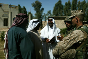 With an aid of an interpreter, Lt Col. Colin P. McNease meets with tribal sheiks near Fallujah May 6. McNease is the officer-in-charge of the 3rd Civil Affairs Group detachment under Regimental Combat Team 1. The 3rd CAG has taken on prjects to improve life for the villagers, including paving a two-kilometer road that will run through two villages and providing 50 tons of fertilizer as the planting season nears for farmers.
(USMC photo by Sgt. Jose E. Guillen) Photo by: Sgt. Jose E. Guillen